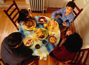 Image of a family eating together at the table. 