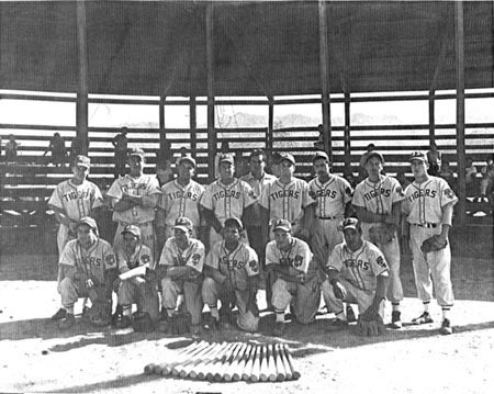 Black and white photo of a baseball team called the Tigers posing in a stadium.