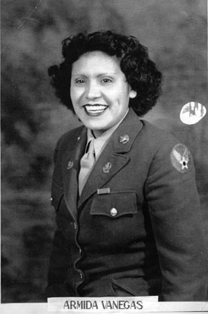 Black-and-white portrait of a woman in a military uniform smiling.