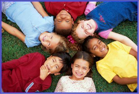 children in circle laying on grass