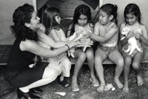 image of4 girls playing with puppies