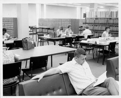 Students in the reading room with card catalogs, 1966