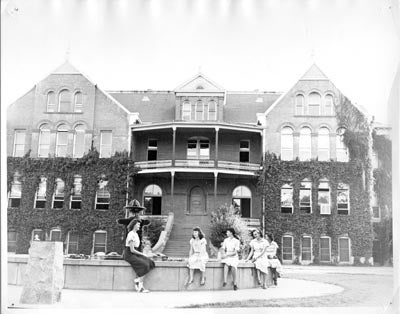 Students sitting on the fountain in front of Old Main, 1940