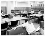 Students in the reading room with card catalogs, 1966