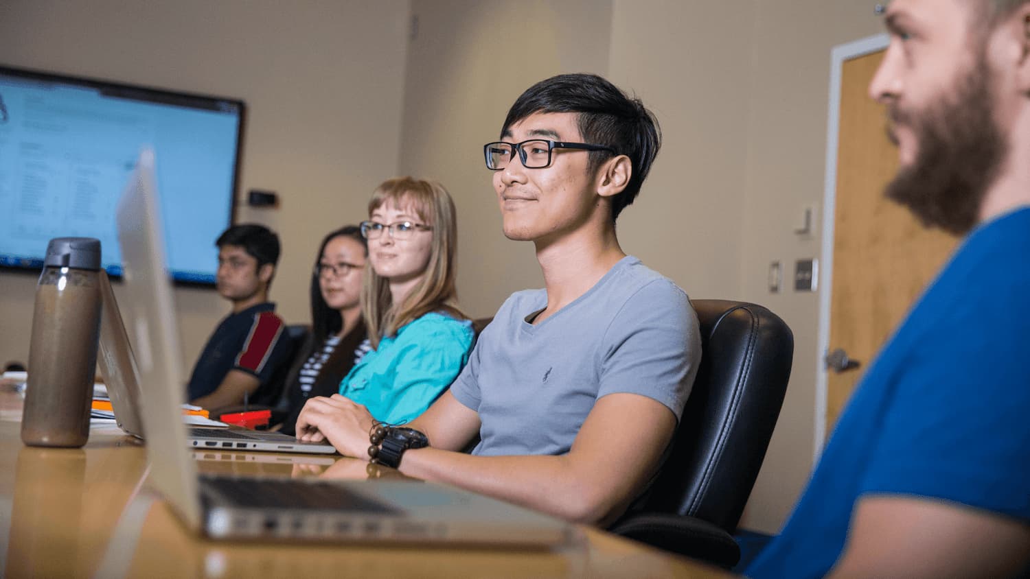 Students in a conference room with laptops