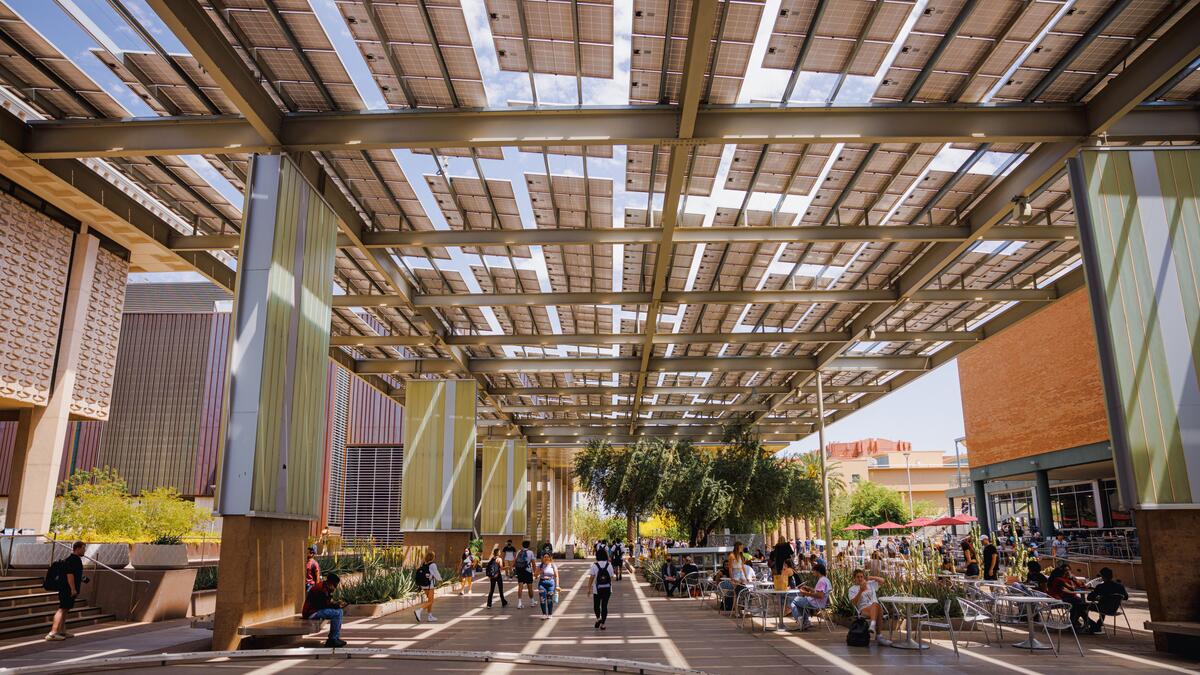 Students walking in the solar panel covered plaza outside of Memorial Union at the ASU Tempe campus