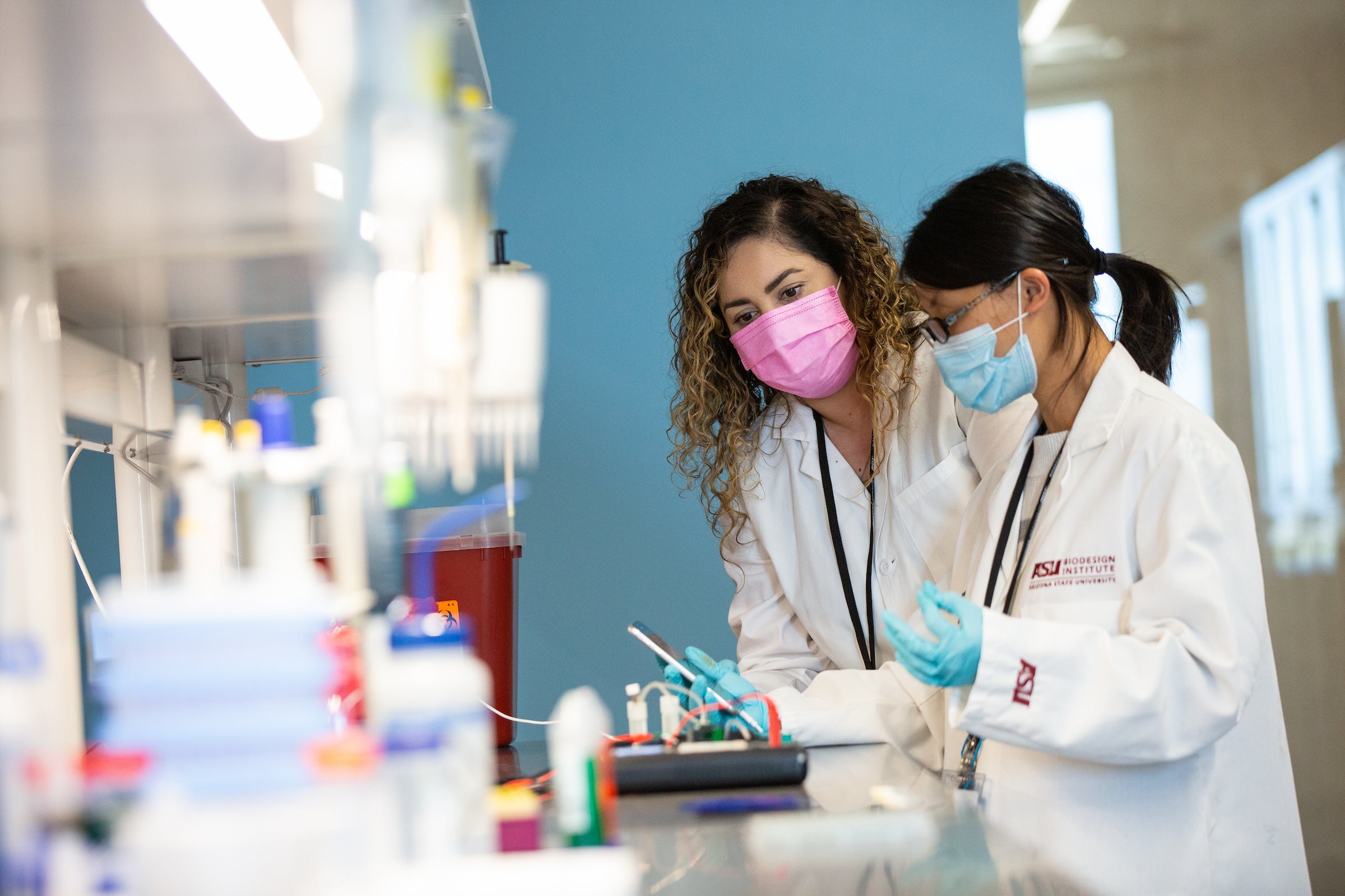 Two women working on an experiment with a phone in a medical lab