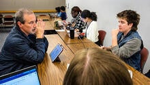 Professor and students chatting at desks